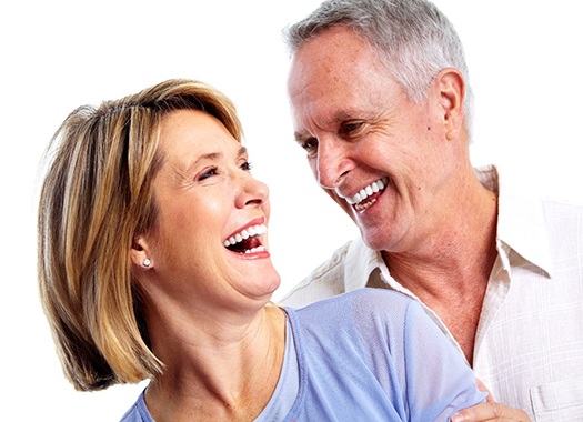An older couple laughing and smiling because of the new confidence they have in their smiles