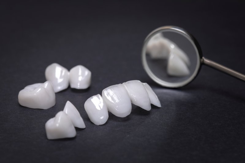 Veneers and dental crowns sitting against a black background